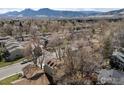 Scenic aerial view of a residential neighborhood with mountain views and mature trees at 4275 Corriente Pl, Boulder, CO 80301