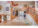 Elegant foyer with tile flooring, staircase with iron railings, and views into the living spaces at 4514 Hoot Owl Dr, Berthoud, CO 80513