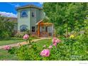 Charming two-story home with lush landscaping and a stone pathway leading to the entrance at 4514 Hoot Owl Dr, Berthoud, CO 80513