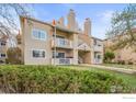 Multi-level condo building with balconies, landscaped lawn, and exterior stairs at 4945 Twin Lakes Rd # 39, Boulder, CO 80301