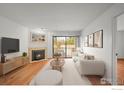 Inviting living room featuring a fireplace, hardwood floors, and balcony access at 4945 Twin Lakes Rd # 39, Boulder, CO 80301