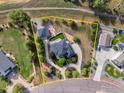 Aerial view showcases the property's layout, lush greenery, detached garage and circular driveway at 5700 Eagle Shadow Ave, Brighton, CO 80602