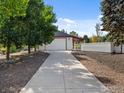 Long driveway leads to a detached garage with covered parking area, adding convenience and charm at 5700 Eagle Shadow Ave, Brighton, CO 80602
