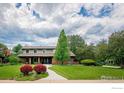 Charming two-story home with a well-manicured lawn, mature trees, and a welcoming walkway at 6916 Hunter Pl, Boulder, CO 80301