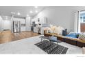 Bright open-plan living room showcasing modern design, a comfortable sofa, and hardwood floors at 702 S Fulton Ave, Fort Lupton, CO 80621