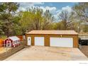 Spacious two-car garage and quaint shed with a fenced yard, suitable for storage and outdoor activities at 7390 Ute Hwy, Longmont, CO 80503