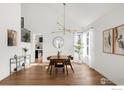 Dining room boasts a modern light fixture, hardwood floors, and natural light at 8542 Waterford Way, Niwot, CO 80503