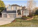 Inviting two-story home featuring a three-car garage, well-maintained lawn, and charming front entryway at 8542 Waterford Way, Niwot, CO 80503
