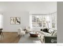 Bright living room featuring hardwood floors, large windows, and modern furnishings at 8542 Waterford Way, Niwot, CO 80503
