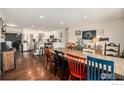 Open-concept dining room featuring hardwood floors and seamlessly connecting to a modern, well-lit kitchen at 9331 Irving St, Westminster, CO 80031
