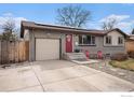 Inviting home with a gray brick facade, a red door, and a driveway leading to an attached garage at 9331 Irving St, Westminster, CO 80031