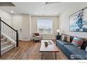 Bright living room with wood floors, comfortable seating, and a large window at 111 Ambrose St, Erie, CO 80516