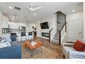 Open living space with a modern fireplace, kitchen with breakfast bar, and staircase at 111 Ambrose St, Erie, CO 80516