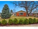 Charming brick and beige home featuring a well-manicured lawn and mature trees at 1185 W Midway Blvd, Broomfield, CO 80020