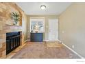Cozy living room featuring a stone fireplace, neutral paint, and tile floors leading to a bright window at 1185 W Midway Blvd, Broomfield, CO 80020