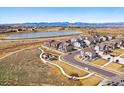 Scenic aerial view showcases a neighborhood with pond, walking trails, community park, and mountain views at 1365 Shale Dr, Erie, CO 80516