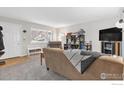 Cozy living room with neutral carpet, bright window, and comfortable seating at 16 Texas Ln, Longmont, CO 80501