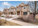 Charming townhome with brick accents, white picket fence, and well-maintained landscaping at 16022 W 63Rd Ln # A, Arvada, CO 80403