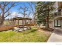 Shared backyard area with wooden pergola featuring seating and beautiful views of the surrounding nature at 1607 Cottonwood Dr # 14, Louisville, CO 80027