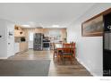 Eat-in kitchen featuring stainless steel appliances, light wood cabinets and a cozy dining area at 1622 Quivira Dr, Denver, CO 80229