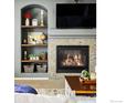 Cozy fireplace with stone accents and built-in shelving, perfect for relaxation and display at 2353 Aral Dr, Longmont, CO 80504
