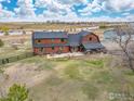 Expansive property featuring a charming log home with a spacious backyard and inviting outdoor patio area at 2587 Horseshoe Cir, Longmont, CO 80504