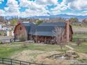 Stunning log home with mountain views, complemented by a picturesque pond and lush greenery at 2587 Horseshoe Cir, Longmont, CO 80504