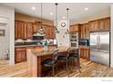Gourmet kitchen features custom wood cabinets, stainless appliances, large island, and pendant lighting at 2714 Calmante Pl, Superior, CO 80027