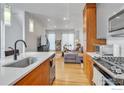 Modern kitchen flowing into living area with stainless steel appliances and hardwood floors at 3043 W 19Th Ave, Denver, CO 80204