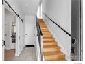 Entryway with wood staircase, tile flooring, sliding barn door, and white painted walls at 3043 W 19Th Ave, Denver, CO 80204