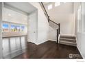 Grand entryway with hardwood floors, a staircase with black wrought iron and natural light at 313 Orion Cir, Erie, CO 80516