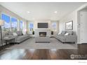 Bright living room featuring large windows, stone fireplace, and neutral decor perfect for relaxing and entertaining at 313 Orion Cir, Erie, CO 80516