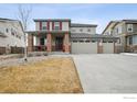 Charming two-story home featuring a three-car garage and a welcoming brick-accented front porch at 4426 Sidewinder Loop, Castle Rock, CO 80108