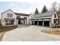 Contemporary home showcasing a paver driveway, attached three-car garage, stone accents, and sleek black window frames at 706 Juniper Ave, Boulder, CO 80304