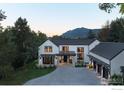 Beautiful home exterior with a stone driveway and mountain views in the background, complemented by lush green landscaping at 706 Juniper Ave, Boulder, CO 80304