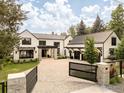A luxurious home with a grand gated entrance and a spacious paved driveway leading to the garage at 706 Juniper Ave, Boulder, CO 80304