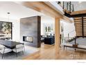Open concept living space featuring wood floors, a modern fireplace, and an elegant staircase with glass railings at 706 Juniper Ave, Boulder, CO 80304