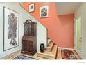 Inviting entryway featuring an antique secretary and a staircase with decorative artwork at 747 Meadow Glen Dr, Boulder, CO 80303