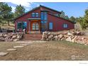 Stately home with a unique wooden arched doorway, stone accents and a large front yard with rock terracing at 8543 Middle Fork Rd, Boulder, CO 80302