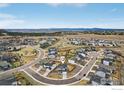 Aerial view of a neighborhood highlighting a two-story home with a well-manicured lawn at 100 Stinson Pl, Castle Pines, CO 80108