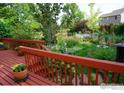 Inviting backyard with wooden deck overlooking a serene garden with colorful flowers and greenery at 1026 Red Oak Dr, Longmont, CO 80504
