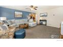 Open-concept living room boasts neutral tones, plush seating, modern furnishings, and lots of natural light at 103 Division Blvd, Platteville, CO 80651