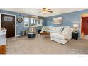 Comfortable living room featuring plush seating, neutral carpet, stylish décor, and abundant natural light at 103 Division Blvd, Platteville, CO 80651