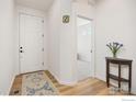Bright entryway featuring wood floors and a view into another room with carpet at 1059 Larkspur Dr, Erie, CO 80516