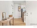 Open hallway with wood flooring, neutral walls and decor leading to the staircase at 1059 Larkspur Dr, Erie, CO 80516