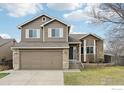 Two-story home featuring a two-car garage, stone accents, and a well-manicured front lawn at 12597 Eliot St, Broomfield, CO 80020