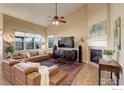 Bright living room featuring vaulted ceilings, large windows, fireplace, and comfortable leather sofas at 133 Peppler Dr, Longmont, CO 80504