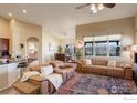 Open living area with large windows, leather sofas, and seamless flow to dining space at 133 Peppler Dr, Longmont, CO 80504