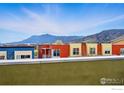 Scenic view from balcony overlooking colorful townhomes and majestic mountain range under a blue sky at 1351 Yellow Pine Ave, Boulder, CO 80304