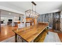 Open dining area showcasing rustic wood table and bench with views of the kitchen and living spaces at 13905 W 21St Ave, Golden, CO 80401